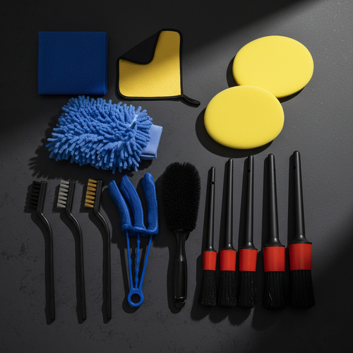 15-piece car detailing kit flat lay on dark charcoal background including chenille mitt, foam pads, microfiber towels, detail brushes and wire brushes